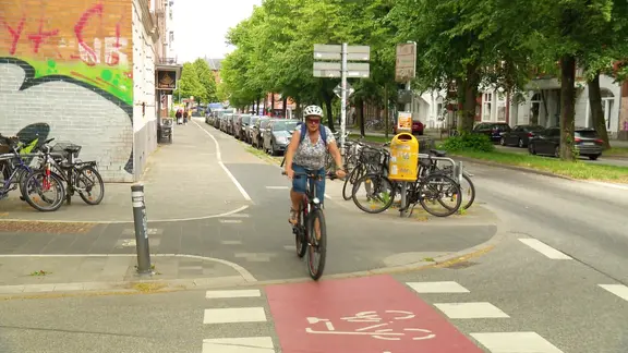 Eine Frau fährt auf einem Radweg.