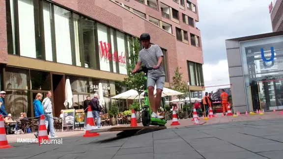 Ein E-Rollerfahrer auf einem Hindernisparcours in der Hafencity. | Screenshot Ein E-Rollerfahrer auf einem Hindernisparcours in der Hafencity.