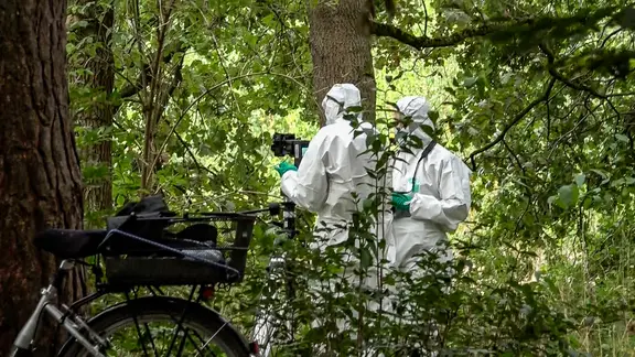 Polizeibeamte in weißen Overalls suchen nach Spuren nach einem Leichenfund am Silbersee. | TeleNewsNetwork Polizeibeamte in weißen Overalls suchen nach Spuren nach einem Leichenfund am Silbersee.