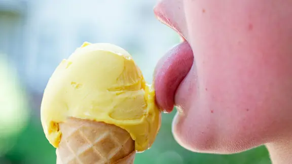 Ein Kind schleckt an einer Kugel Eis in einer Waffel. | picture alliance/dpa | Uwe Anspach Ein Kind schleckt an einer Kugel Eis in einer Waffel.