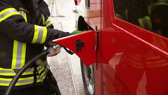Ein Feuerwehrmann betankt ein Fahrzeug | NDR, Kolja Niber Ein Feuerwehrmann betankt ein Fahrzeug