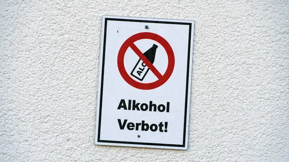Ein Schild an einer Wand verbietet den Konsum von Alkohol. | picture alliance / CHROMORANGE | Elke Münzel Ein Schild an einer Wand verbietet den Konsum von Alkohol.