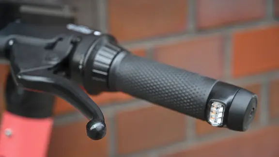 Ein E-Roller, der bereits mit einem Blinker ausgestattet ist. | picture alliance/ABBfoto | - Ein E-Roller steht auf einer Straße.