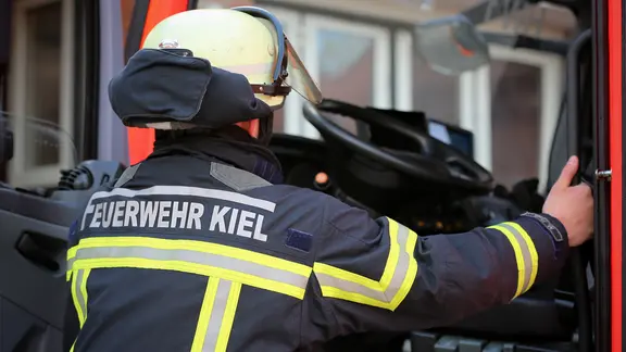 Schriftzug "Feuerwehr Kiel" ist auf der Uniform eines Feuerwehrmannes beim Einsteigen in ein Einsatzfahrzeug zu sehen. | NDR, Pavel Stoyan Schriftzug "Feuerwehr Kiel" ist auf der Uniform eines Feuerwehrmannes beim Einsteigen in ein Einsatzfahrzeug zu sehen.