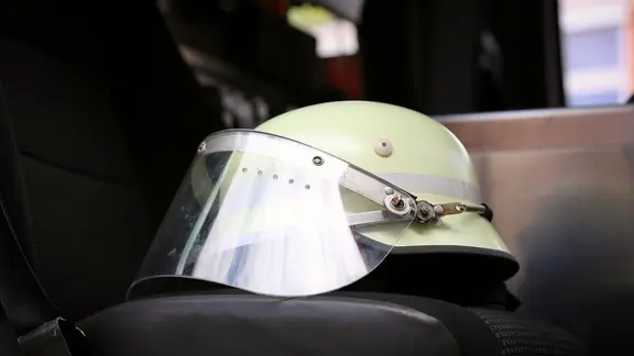 Ein Schutzhelm liegt auf dem Autositz eines Feuerwehrautos. | NDR, Pavel Stoyan Ein Schutzhelm liegt auf dem Autositz eines Feuerwehrautos.