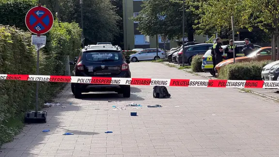 PKW hinter Polizeiabsperrung, auf dem Boden daneben ein Rucksack und Kleinteile | René Schröder PKW hinter Polizeiabsperrung, auf dem Boden daneben ein Rucksack und Kleinteile