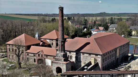 Die sogenannte Hexenburg ist ein Unikat in Sachsen. | Frank Milbrath Blick auf ein historisches Gebäude-Ensemble mit einem Schornstein.