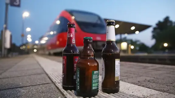 Bierflaschen stehen auf einem Bahnsteig | picture alliance / SNS Bierflaschen stehen auf einem Bahnsteig