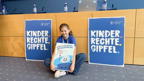 Ida, 11 Jahre, findet, dass die Älteren nicht alles bestimmen können, bloß weil sie älter sind. | NDR, Uwe Jahn Ida, 11 Jahre, vom Hans-Geiger-Gymnasium sitzt mit einem Plakat auf dem Boden.