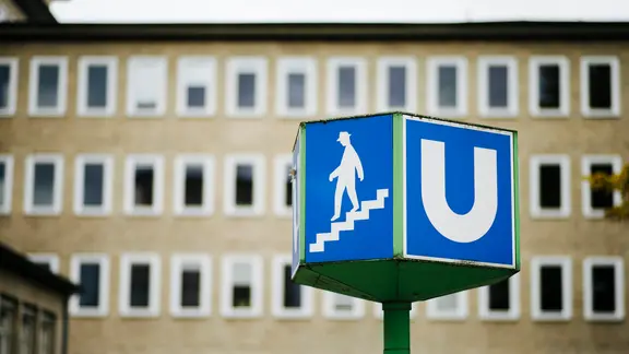 Im Vordergrund ein Schild für die Ubahn in Hannover mit einem Gebäude der Leibniz Universität am Königsworther Platz im Hintergrund. | NDR, Julius Matuschik Im Vordergrund ein Schild für die Ubahn in Hannover mit einem Gebäude der Leibniz Universität am Königsworther Platz im Hintergrund.