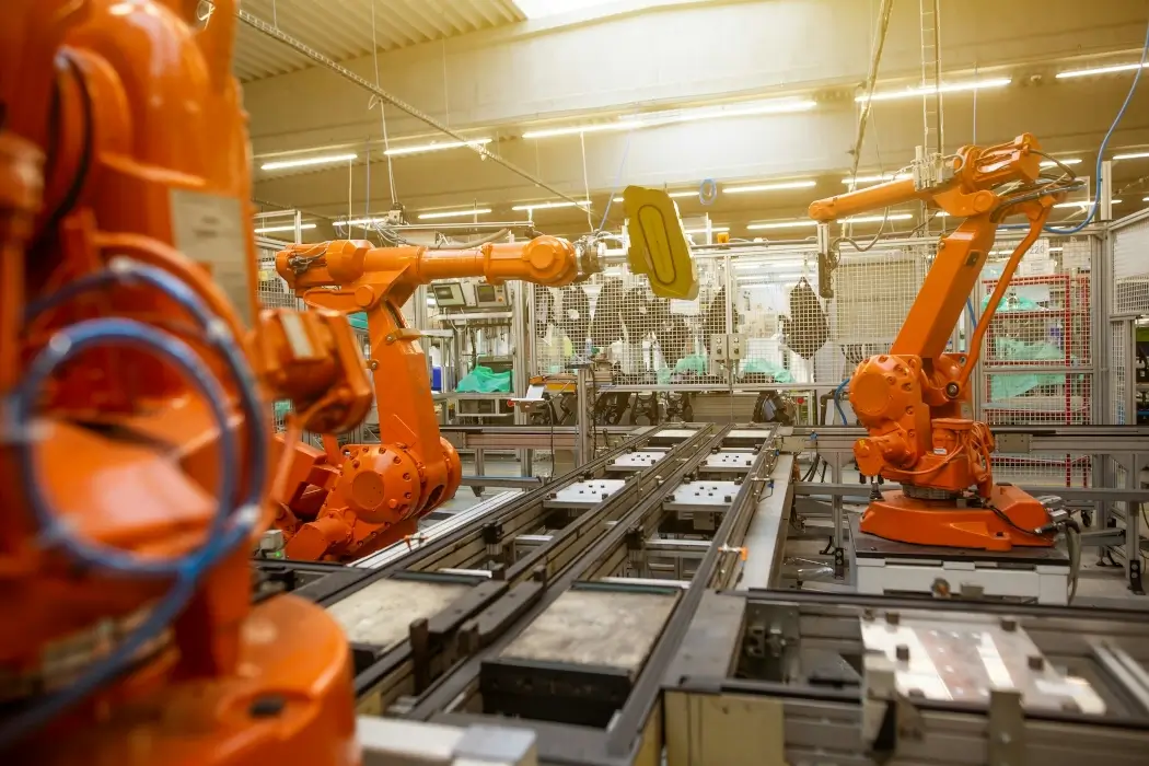 Robotic arms inside an industrial manufacturing facility.