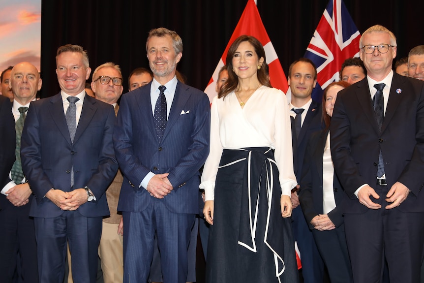 King Frederik and Queen Mary pose with businesspeople during an event in Melbourne