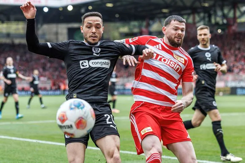 FC St. Pauli's Mathias Pereira Lage (L) and Union Berlin's Oliver Burke (R) battle for the ball during the German Bundesliga soccer match between 1. FC Union Berlin and FC St. Pauli at the Stadion An der Alten Foersterei. Andreas Gora/dpa