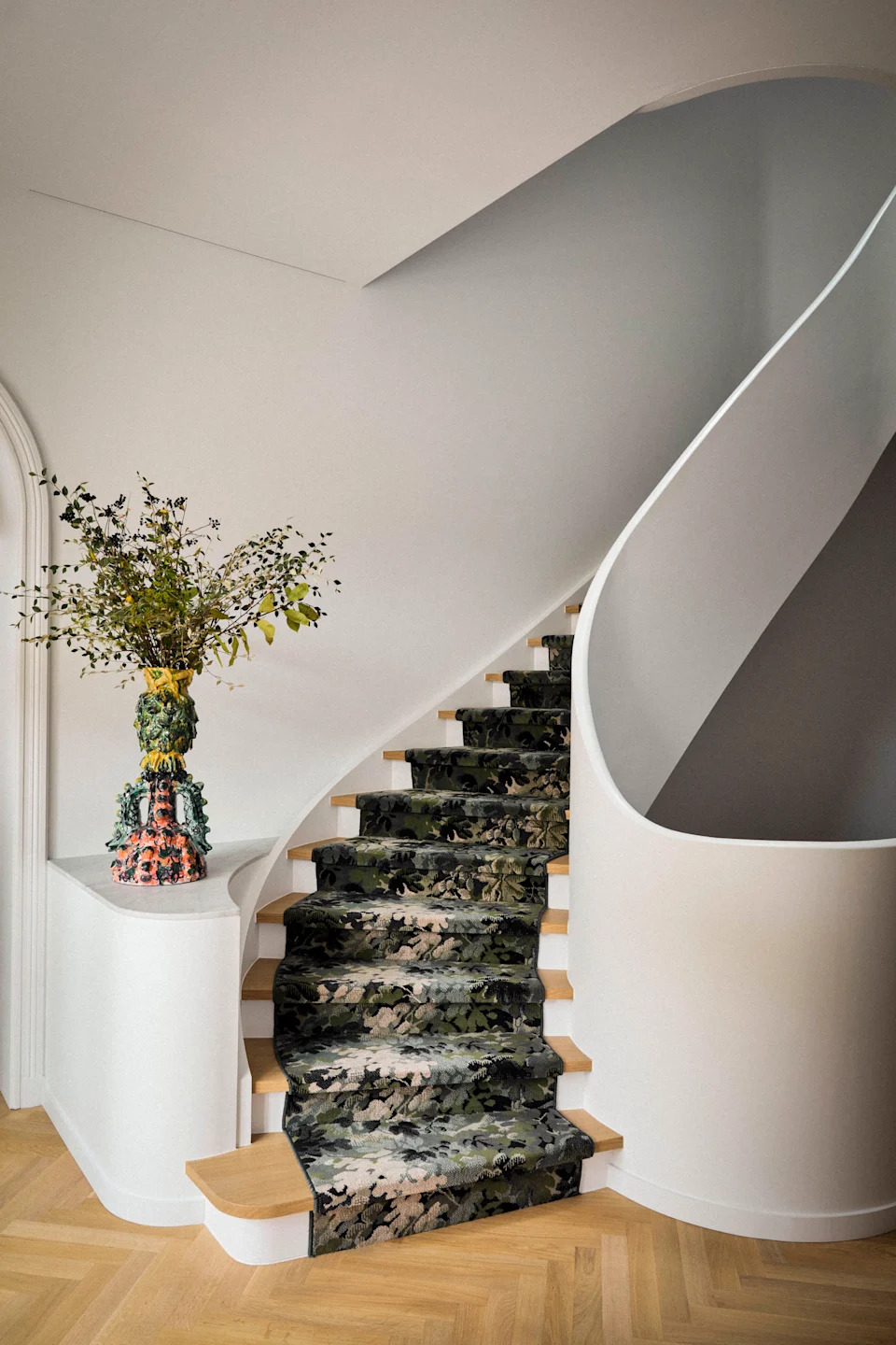 This winding staircase has a sculptural quality, with a printed runner