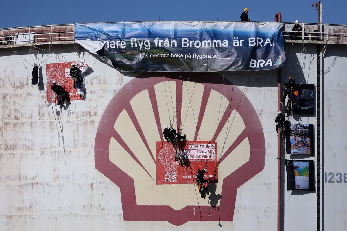 Activists of the environmental NGO Greenpeace climb a storage tank to hang a banner (AFP/Getty)