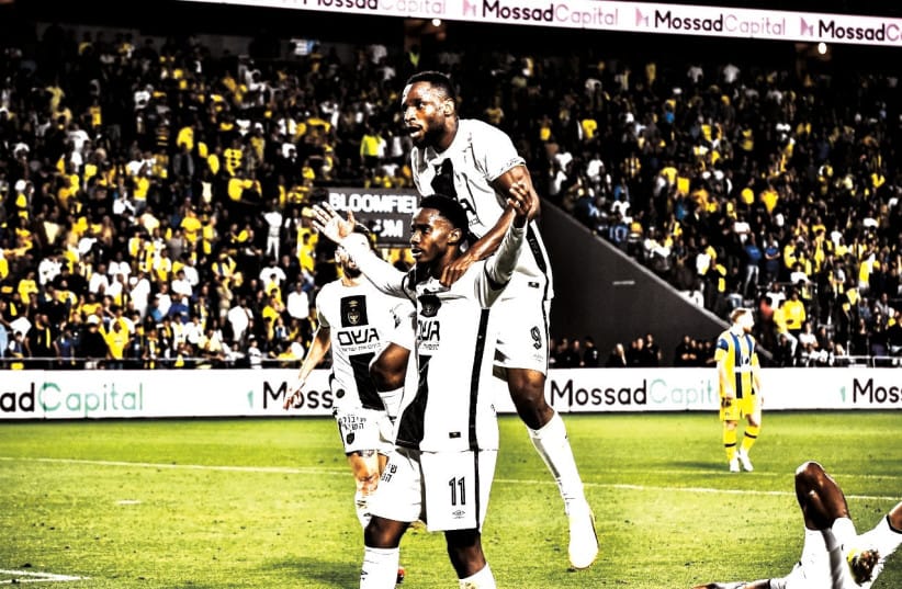 TIMOTI MUZIE (11) celebrates with his Beitar Jerusalem teammates after scoring the game-winning goal in the crucial 2-1 victory over Maccabi Tel Aviv.