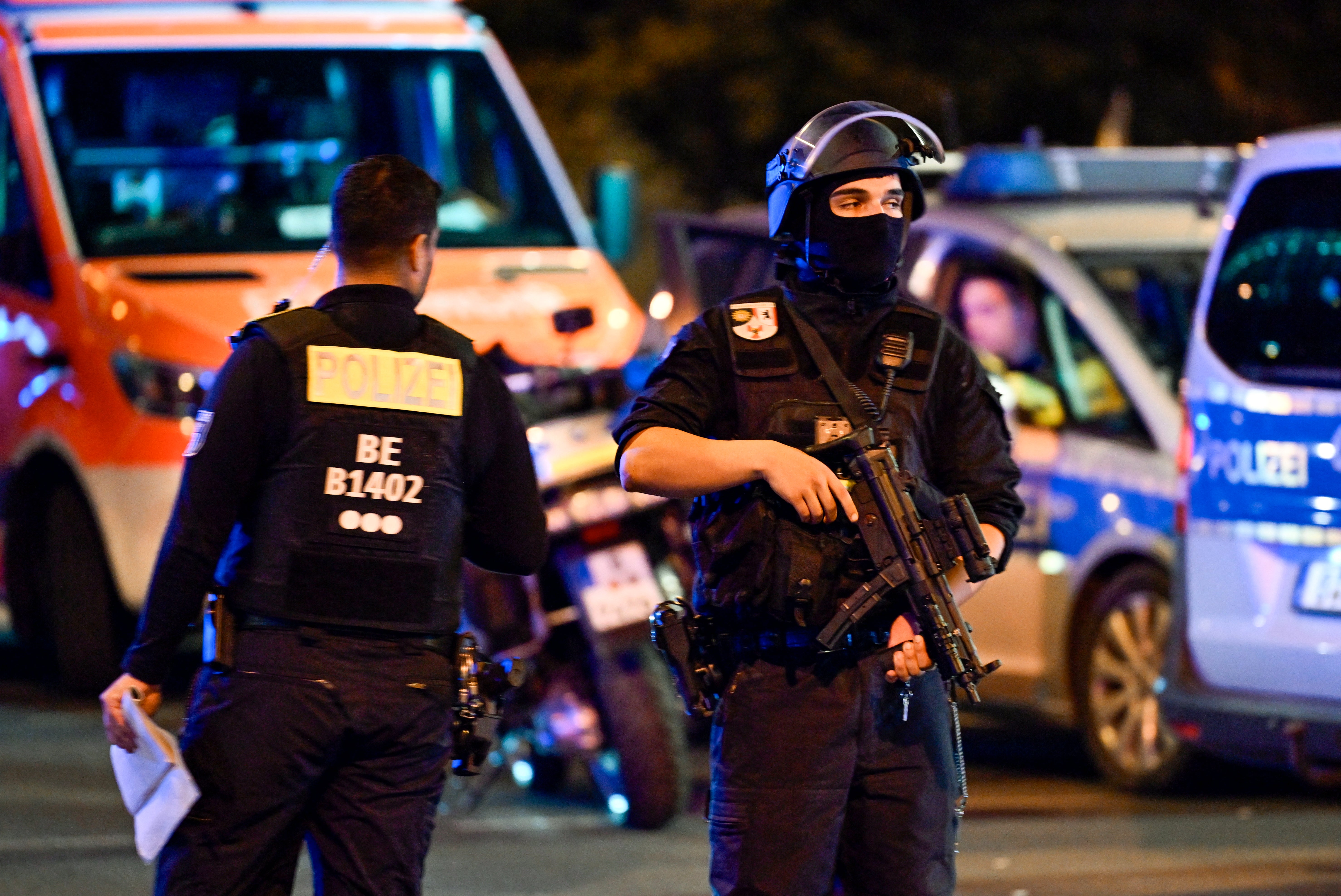 Armed police stand near the scene where one person was killed and around 16 injured after a car struck people on the outskirts of the Christopher Street Day (CSD) parade in Berlin, on July 25, 2026
