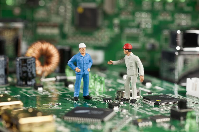 Kaks miniatuurset kujukest, kes töötavad arvuti emaplaadi kallal