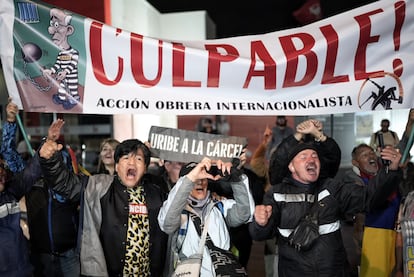Detractores de Álvaro Uribe celebran la condena al exmandatario colombiano, afuera de los juzgados de Paloquemao, en Bogotá.
