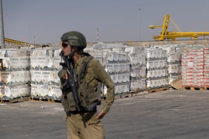 Un soldado israelí custodia paquetes de ayuda humanitaria en el paso fronterizo de Karem Shalom, en una imagen tomada el 24 de julio. La fotografía fue revisada por el Ejército israelí antes de su difusión. 