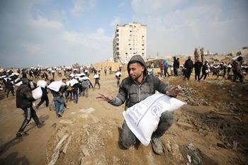 Palestinos llevan bolsas de harina