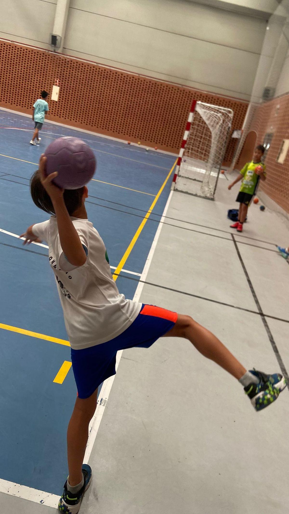 Un joven del campus de verano del Balonmano Zamora trata de anotar desde el extremo.