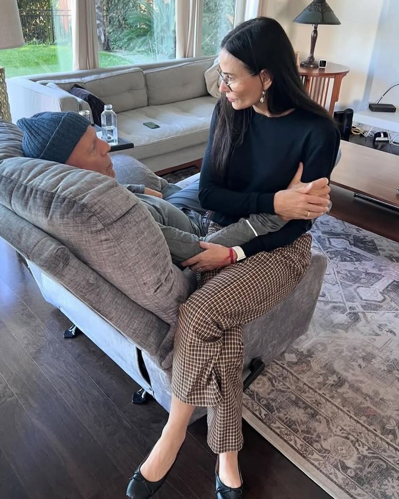 Demi Moore con Bruce Willis sentados en un sofá