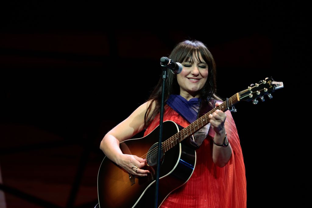 Plano medio de Eva Amaral tocando la guitarra en un concierto