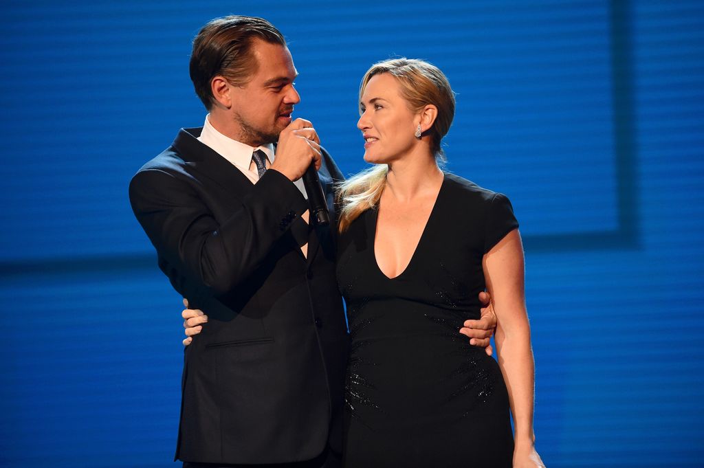 Plano medio de Kate Winslet y Leonardo DiCaprio en el escenario dando un discurso
