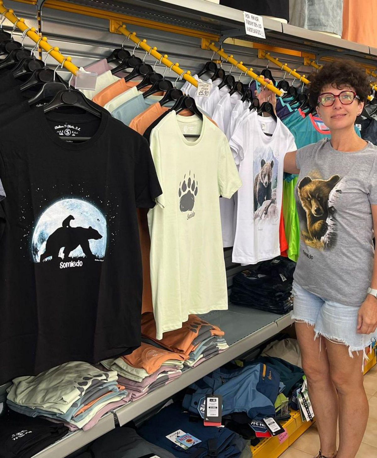 LAS CAMISETAS DE SOMIEDO. En la foto de arriba, Joseph Zada posa con la camiseta en el vídeo promocional; a su derecha, con Grace y Bell en TikTok. Sobre estas líneas, Azucena Álvarez, en Casa Seni. | @THEHUNGERGAMES IG / @JOSEPHZADAINABEARSHIRT TIKTOK / LNE