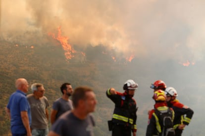 Varias personas observan el incendio forestal, a 24 de agosto, en La Baña (León).