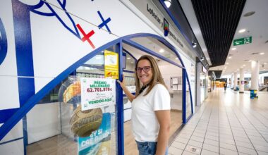 Delia, dependienta de la administración del El Mirador posan con el cartel del premio.