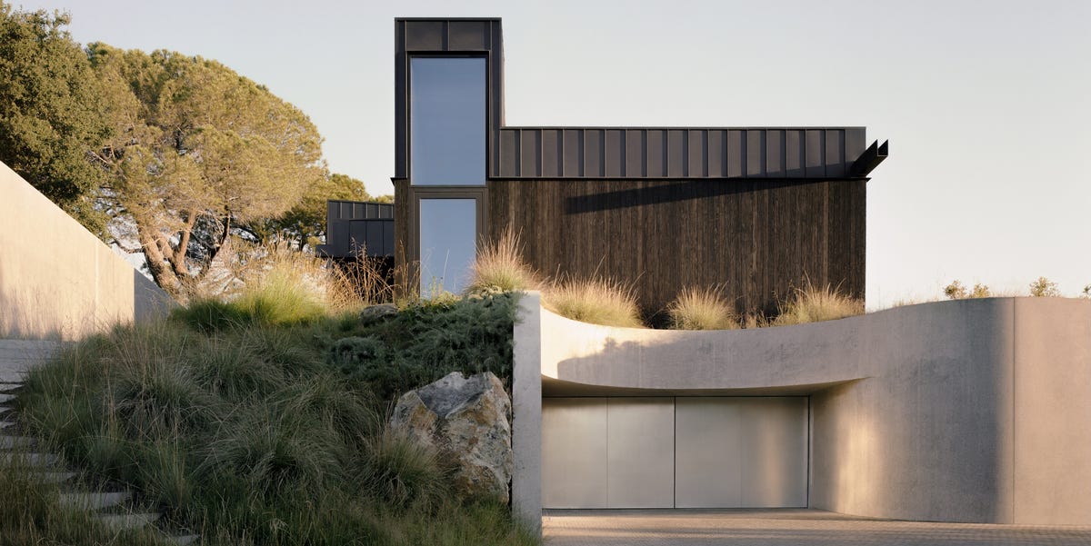 Esta espectacular y moderna casa en la montaña tiene una original cueva con piscina, espacios abiertos, patios y nace de las ruinas de una antigua vivienda