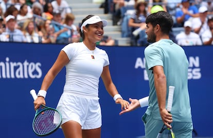 Alcaraz y Raducanu chocan sus manos tras un intercambio en la pista central del US Open.