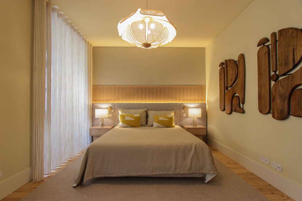 Dormitorio en tonos neutros y esculturas de madera en la pared