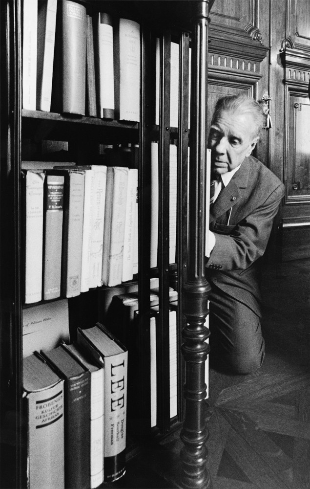 Sara Facio  (Buenos Aires, Argentina, 1932-2024)  Jorge Luis Borges de rodillas ante los libros, 1968  Impresión al gelatino bromuro de plata sobre papel, 37 x 23 cm  Colección Museo Nacional de Bellas Artes