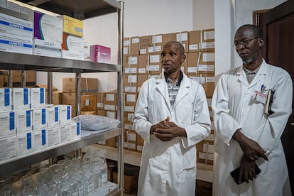 Alpha Baldé, farmacéutico jefe (izquierda), y el doctor Ansoumane Kourouma, pediatra y director interno del Hospital de Dubreka (derecha), muestran los medicamentos que aún quedan para el tratamiento de la malaria. 