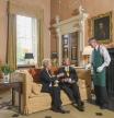 Caucasian butler serving business people in formal mansion parlor - Fotografía de stock