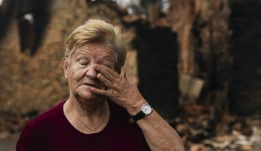 Una vecina de Castrocalbón, junto a una vivienda que ha sido destruida por los incendios.
