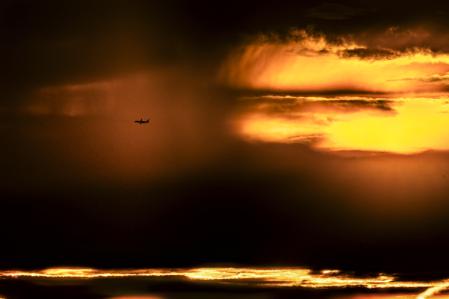 Fotografía de un avión surcando el cielo del amanecer.
