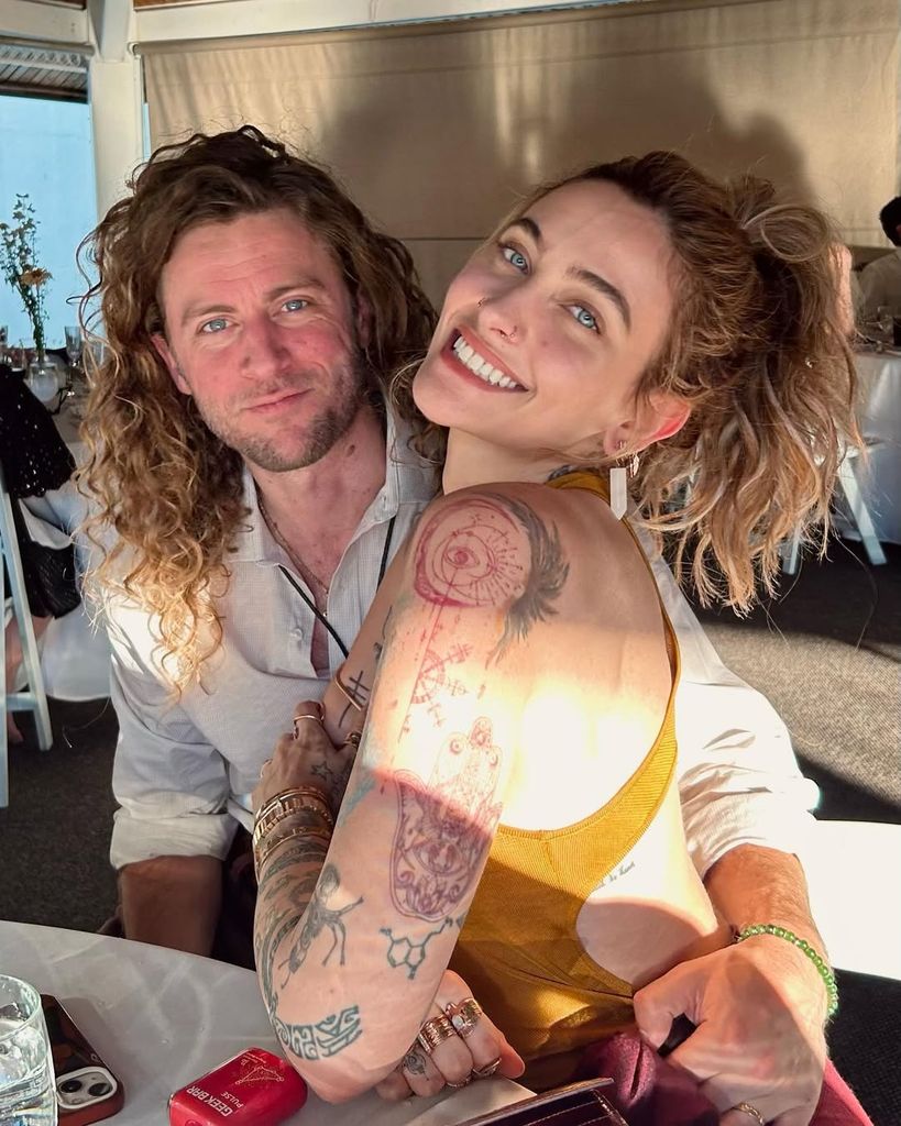 Paris Jackson y Justin Long posando juntos en un bar