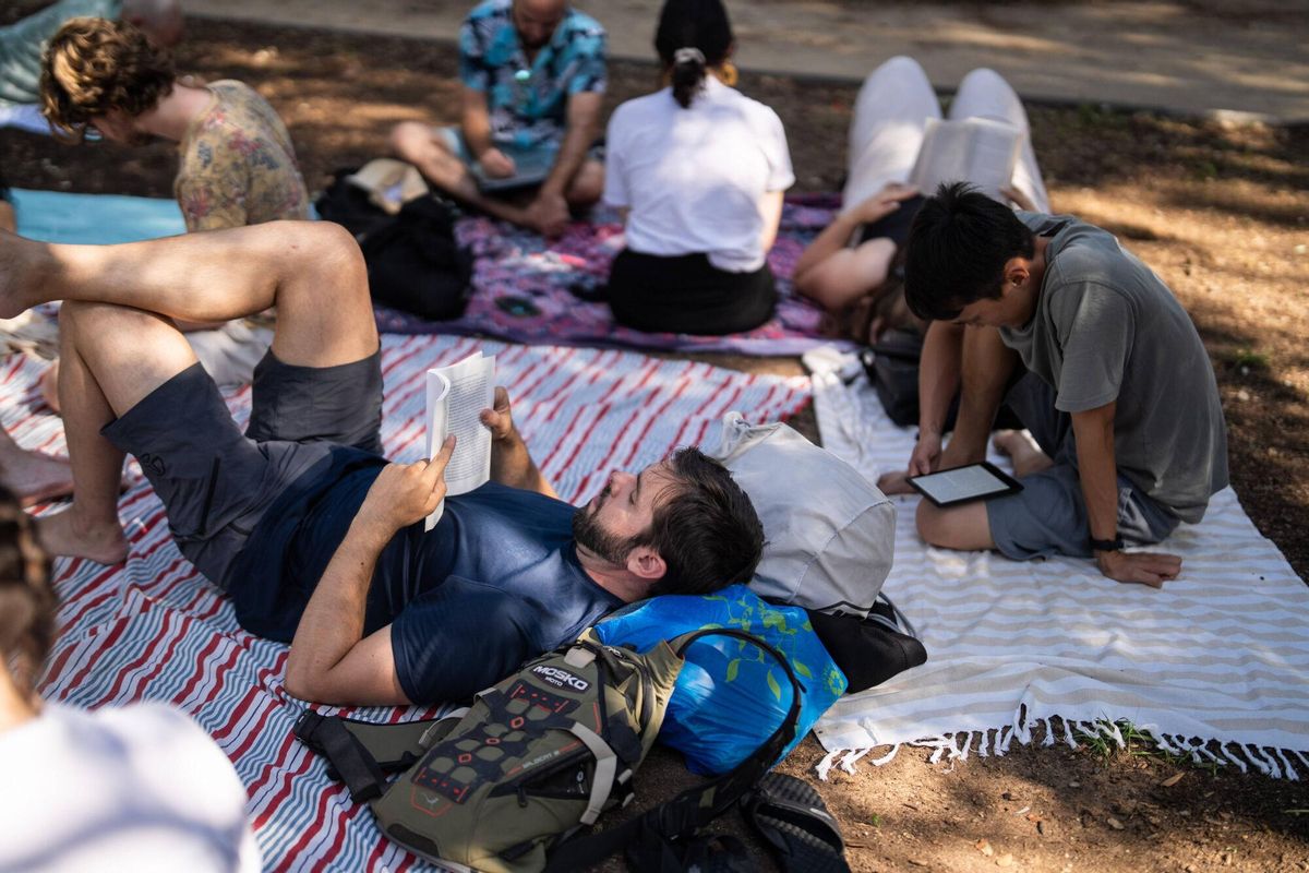 BARCELONA 27/07/2025 Barcelona. Integrantes de un club de lectura en silencio durante su encuentro dominical en el parque de la Estació del Nord, donde comparten una hora de lectura conjunta al aire libre. FOTO de ZOWY VOETEN