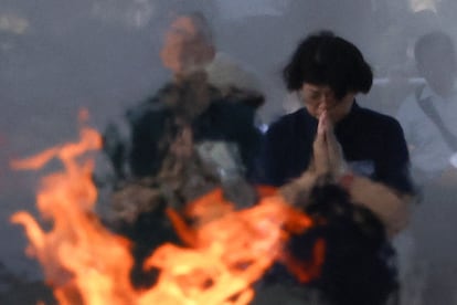 Los asistentes al acto conmemorativo por el 80 aniversario del bombardeo atómico de 1945, rezan frente al cenotafio en memoria de las víctimas en el Parque de la Paz de Hiroshima.