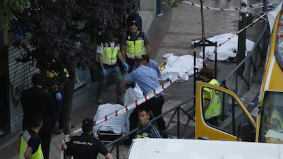 Los policías retiran los cuerpos de las tres víctimas asesinadas en el despacho de Víctor Salas, en la calle Marcelo Usera 40, Madrid, la tarde del 22 de junio de 2016.