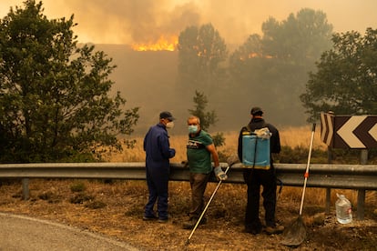 Varios vecinos observan el fuego aproximándose a la carretera de Filiel, en Léon.