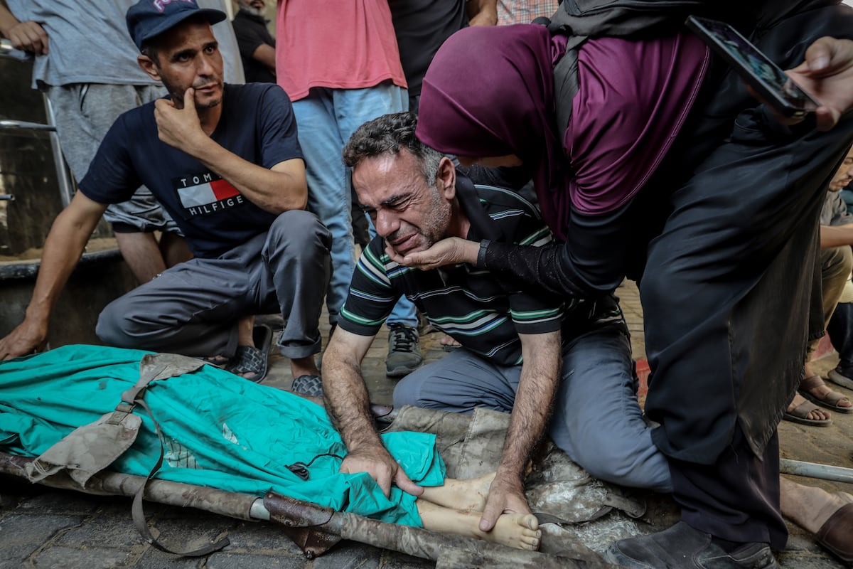 Un hombre llora ante el cadáver de un niño víctima de los ataques israelíes, este domingo en Ciudad de Gaza.