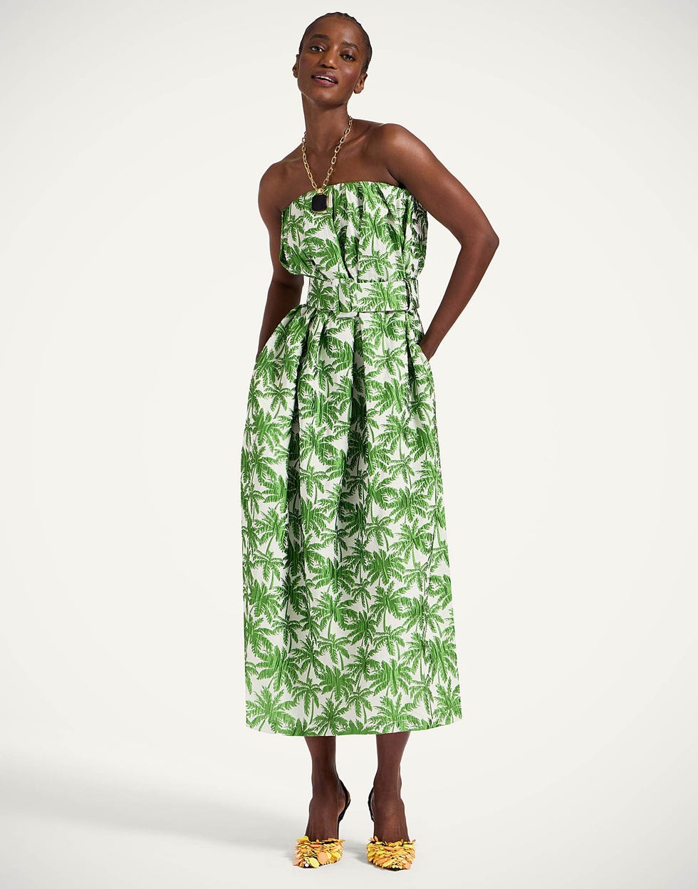strapless green dress with palm leaf pattern and yellow shoes