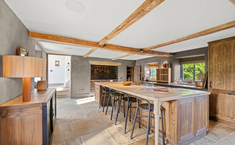 Imagen principal - La vivienda presenta un estilo rústico con una cocina con gabinetes de madera y dormitorios con vigas vistas 