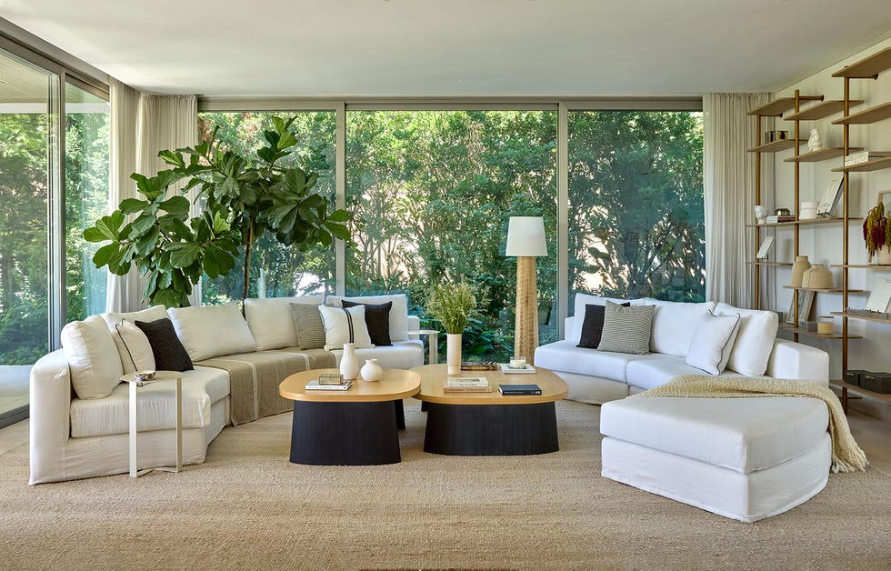 casa de cristal moderna con piscina y decoracion minimal en blanco con sofas curvos