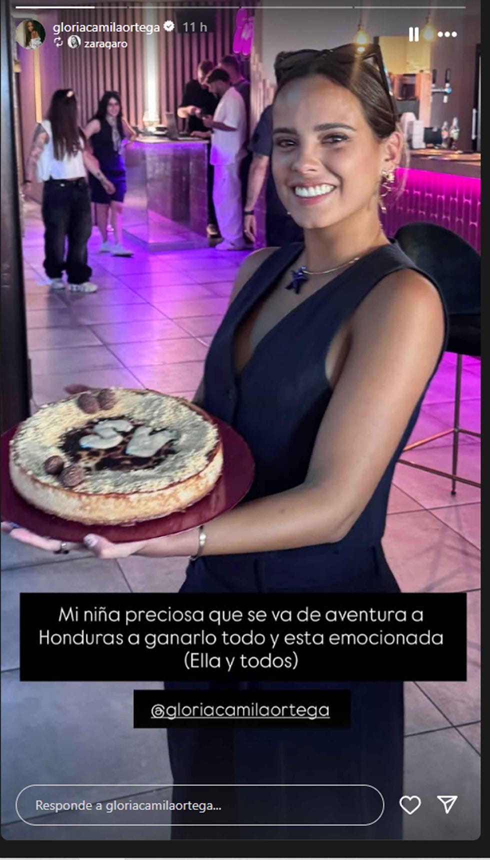 celebratory event featuring a person presenting a cake